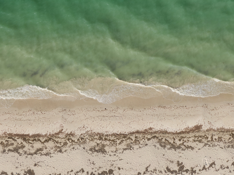 Aerial view of the turquoise waters and white sandy shoreline of Las Coloradas Yucatan Mexico.