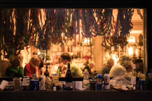 Basel Switzerland 10 March 2025 View of a bar scene during Fasnacht where vibrant streamers contrast with the dark interior and patrons gather amongst bottles and cans. Basel Switzerland 10 March 2025 View of a bar scene during Fasnacht where vibrant streamers contrast with the dark interior and patrons gather amongst bottles and cans.