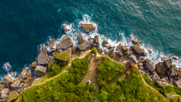 Aerial view of Cabo Frances Viejo with rugged cliffs lush vegetation and turquoise waves crashing against the rocky coastline in Cabrera Maria Trinidad Sanchez Dominican Republic.