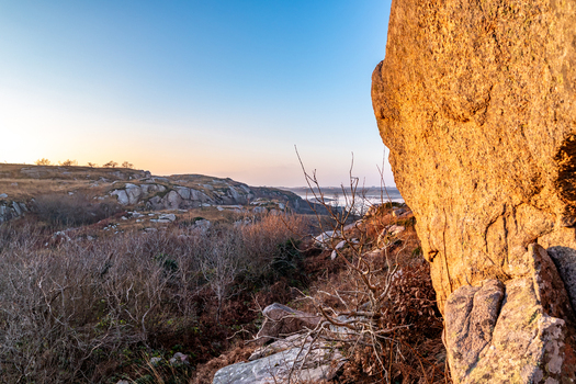 View of Kincasslagh Mass Rock set within a rugged rocky landscape under a clear sky during golden hour in Kincasslagh County Donegal Ireland. View of Kincasslagh Mass Rock set within a rugged rocky landscape under a clear sky during golden hour in Kincasslagh County Donegal Ireland.