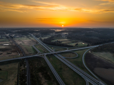 Aerial view of the A5 and A8 highway interchange at sunset with surrounding fields and forests in Olaine parish Olaine Municipality Latvia. Aerial view of the A5 and A8 highway interchange at sunset with surrounding fields and forests in Olaine parish Olaine Municipality Latvia.