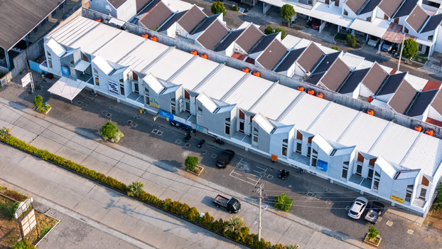 Aerial view of a row of modern commercial buildings with distinctive sawtooth roofs parking area and road in Semarang Central Java Indonesia. Aerial view of a row of modern commercial buildings with distinctive sawtooth roofs parking area and road in Semarang Central Java Indonesia.