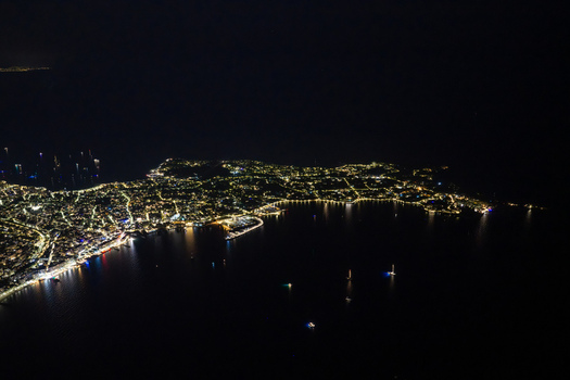 Aerial view of the illuminated coastline at night featuring the harbor city lights and boats on the water in Antibes Provence Alpes Cote d Azur France. Aerial view of the illuminated coastline at night featuring the harbor city lights and boats on the water in Antibes Provence Alpes Cote d Azur France.