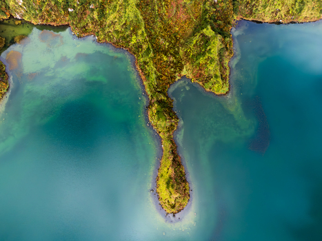 Aerial view of Lagoa do Fogo featuring a narrow green peninsula extending into the turquoise volcanic crater lake surrounded by lush vegetation Agua de Alto Azores Portugal. Aerial view of Lagoa do Fogo featuring a narrow green peninsula extending into the turquoise volcanic crater lake surrounded by lush vegetation Agua de Alto Azores Portugal.
