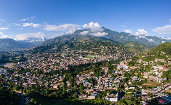 Aerial view of the city of Muzaffarabad with its dense urban layout winding river and surrounding green mountains under a clear blue sky in Muzaffarabad Azad Kashmir Pakistan. Aerial view of the city of Muzaffarabad with its dense urban layout winding river and surrounding green mountains under a clear blue sky in Muzaffarabad Azad Kashmir Pakistan.