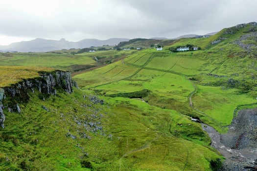 Aerial view of The Brother s Point featuring lush green rolling hills rugged cliffs and a winding path leading through the landscape in Culnacnoc Scotland United Kingdom. Aerial view of The Brother s Point featuring lush green rolling hills rugged cliffs and a winding path leading through the landscape in Culnacnoc Scotland United Kingdom.