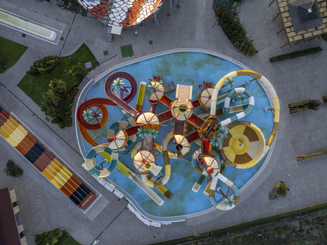 Aerial view of a colorful water park with twisting slides a central pool and palm tree decorations in Bulgaria. Aerial view of a colorful water park with twisting slides a central pool and palm tree decorations in Bulgaria.
