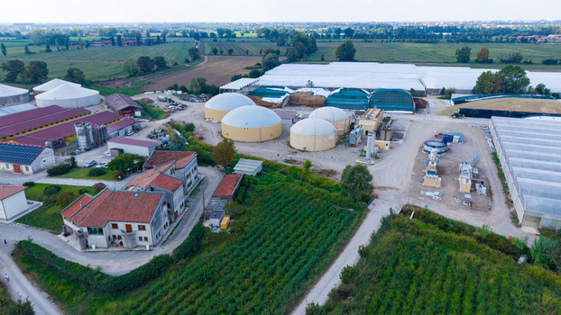 Aerial view of an agricultural facility featuring biogas digesters greenhouses and farm buildings surrounded by fields in Milan Lombardy Italy. Aerial view of an agricultural facility featuring biogas digesters greenhouses and farm buildings surrounded by fields in Milan Lombardy Italy.