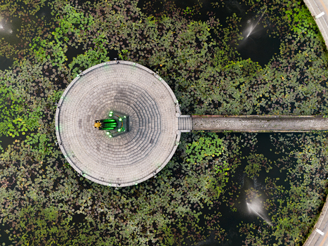 Aerial view of the Tugu Monument in the center of a lotus pond surrounded by water lilies and fountains in Malang East Java Indonesia.