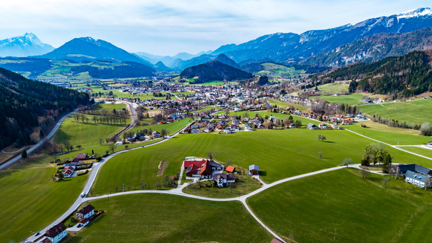 Aerial view of emerald green fields meeting quaint villages nestled beneath snow capped mountains in the Windischgarsten valley Windischgarsten Upper Austria Austria. Aerial view of emerald green fields meeting quaint villages nestled beneath snow capped mountains in the Windischgarsten valley Windischgarsten Upper Austria Austria.