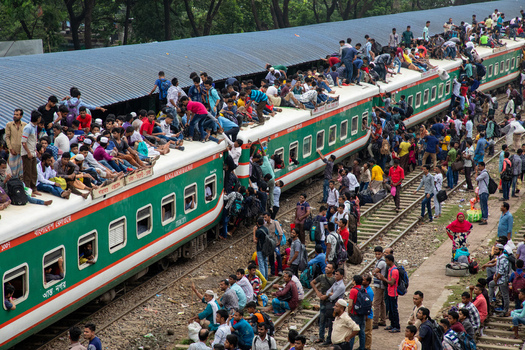 Dhaka Bangladesh 15 June 2018 View of the overcrowded Airport Railway Station with hundreds of passengers sitting on the train roof and hanging from the doors. Dhaka Bangladesh 15 June 2018 View of the overcrowded Airport Railway Station with hundreds of passengers sitting on the train roof and hanging from the doors.