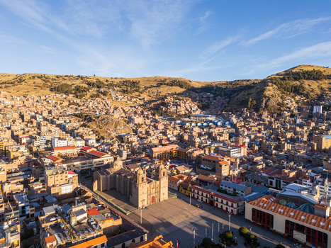 Aerial view of the Puno Cathedral situated in the Plaza de Armas surrounded by the dense urban landscape and hills of Puno Puno Peru.