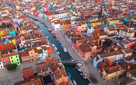 Aerial view of Burano island with its iconic brightly colored houses narrow canals and small boats in Venice Veneto Italy. Aerial view of Burano island with its iconic brightly colored houses narrow canals and small boats in Venice Veneto Italy.