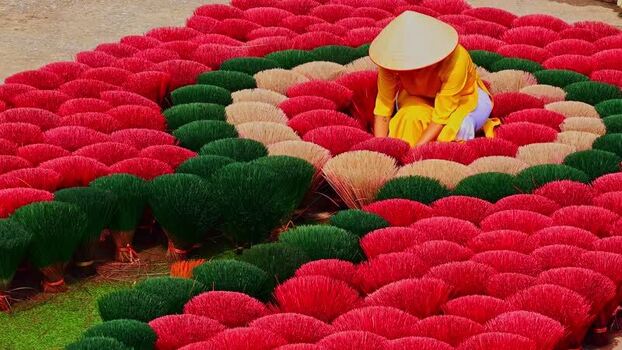 View of a worker among vibrant incense bundles Vietnam.