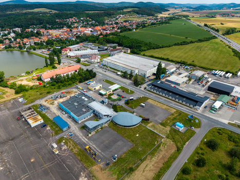 Aerial view of the industrial area and town of Zebrak featuring warehouses a parking lot a nearby lake and green fields in Zebrak Central Bohemian Region Czechia. Aerial view of the industrial area and town of Zebrak featuring warehouses a parking lot a nearby lake and green fields in Zebrak Central Bohemian Region Czechia.