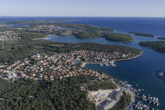Aerial view of the coastal town of Pjescana Uvala with its marina dense pine forests and residential houses in Pjescana Uvala Pula Istria County Croatia.