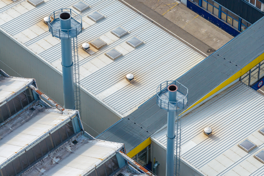 Aerial view of an agricultural machinery production facility with metal rooftops ventilation chimneys and skylights in Plock Mazowieckie Poland. Aerial view of an agricultural machinery production facility with metal rooftops ventilation chimneys and skylights in Plock Mazowieckie Poland.