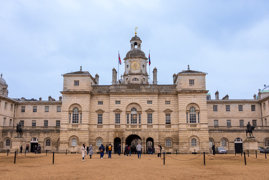 London United Kingdom 12 May 2025 View of the historic Horse Guards building with its central clock tower and people walking across the parade ground in London.