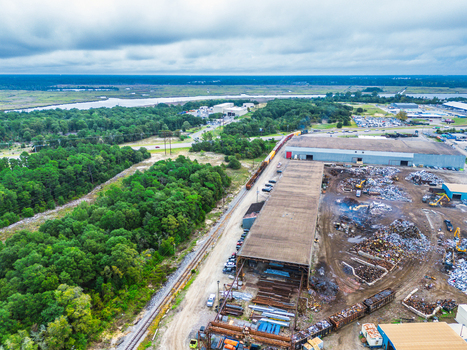 Wilmington United States 18 September 2026 Aerial view of an industrial scrap yard with piles of metal railway tracks and large warehouses surrounded by dense forest under a cloudy sky. Wilmington United States 18 September 2026 Aerial view of an industrial scrap yard with piles of metal railway tracks and large warehouses surrounded by dense forest under a cloudy sky.