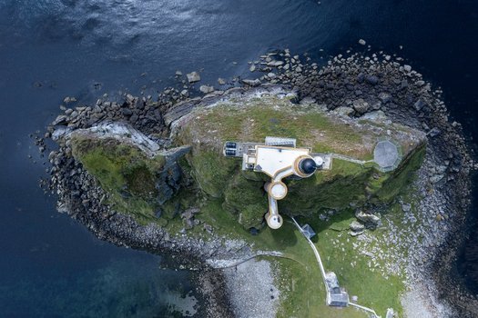 Aerial view of Sanda Island Lighthouse on the rugged cliffs of Sanda Island Argyll and Bute Council Scotland United Kingdom.