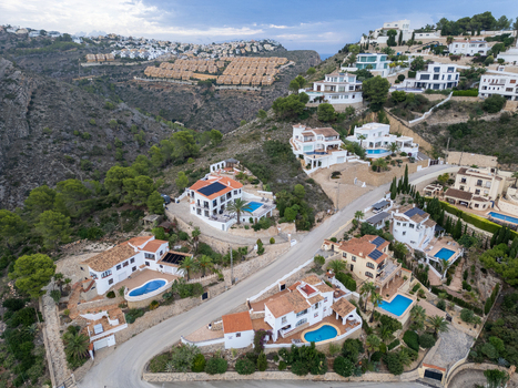 Aerial view of luxury villas with swimming pools nestled on a hillside in Moraira Valencian Community Spain.