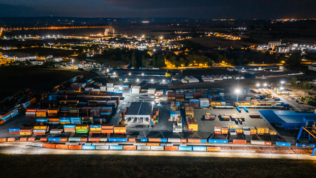 Aerial view of the illuminated RTC Luka Leget container terminal at night featuring rows of colorful shipping containers and freight trains in Sremska Mitrovica Vojvodina Serbia. Aerial view of the illuminated RTC Luka Leget container terminal at night featuring rows of colorful shipping containers and freight trains in Sremska Mitrovica Vojvodina Serbia.