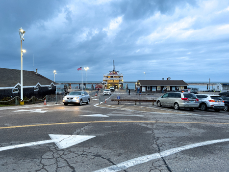Edgartown United States 14 May 2026 View of the ferry terminal at Martha s Vineyard with a large ship docked under a cloudy sky and street lights illuminated.