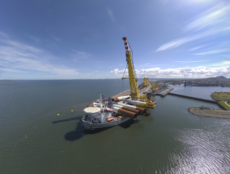 Aerial view of a heavy lift vessel with a large yellow crane carrying industrial components at the Port of Leith in Edinburgh Scotland United Kingdom. Aerial view of a heavy lift vessel with a large yellow crane carrying industrial components at the Port of Leith in Edinburgh Scotland United Kingdom.