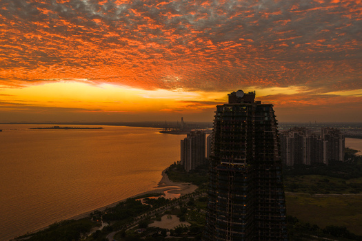 Aerial view of Forest City residential development at sunset with dramatic orange clouds over the coastal landscape in Gelang Patah Johor Darul Ta zim Malaysia.