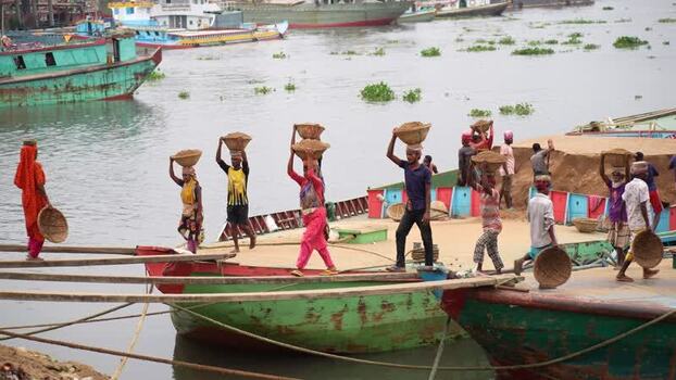 View of workers carrying sand baskets on their heads Bangladesh.
