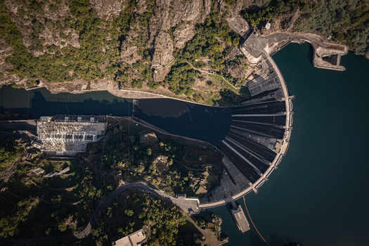 Aerial view of Encoro de Santo Estevo dam and reservoir surrounded by rocky cliffs and lush green vegetation in Ourense Ourense Spain. Aerial view of Encoro de Santo Estevo dam and reservoir surrounded by rocky cliffs and lush green vegetation in Ourense Ourense Spain.