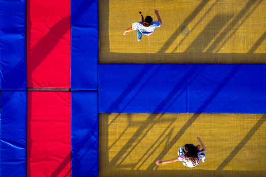 Aerial view of two people jumping on a colorful trampoline with red and blue safety pads in Belgrade City of Belgrade Serbia. Aerial view of two people jumping on a colorful trampoline with red and blue safety pads in Belgrade City of Belgrade Serbia.