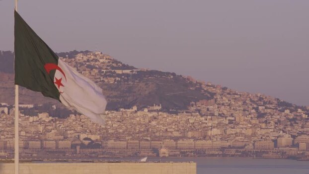 Aerial view of the Algerian flag waving over the city Algeria.