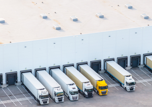 Aerial view of Gdansk Kowale Distribution Centre with multiple semi trucks parked at loading docks showing white warehouse walls and asphalt yard in Kowale Wojewodztwo pomorskie Poland. Aerial view of Gdansk Kowale Distribution Centre with multiple semi trucks parked at loading docks showing white warehouse walls and asphalt yard in Kowale Wojewodztwo pomorskie Poland.