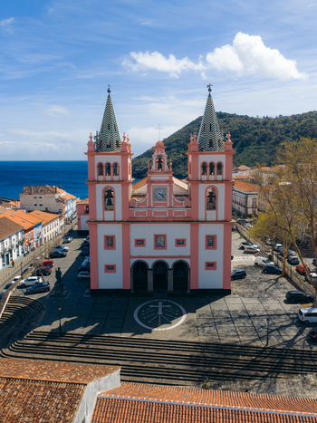 Aerial view of the pink facade of the Cathedral of Angra do Heroismo overlooking the historic square and the blue sea in Angra do Heroismo Azores Portugal.