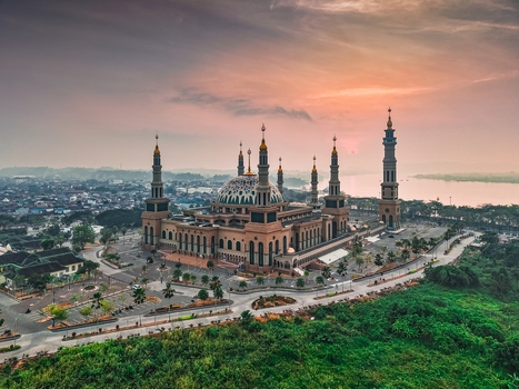 Aerial view of the Baitul Muttaqien Mosque at the East Kalimantan Islamic Center featuring its grand dome and minarets near the Mahakam River in Samarinda East Kalimantan Indonesia.