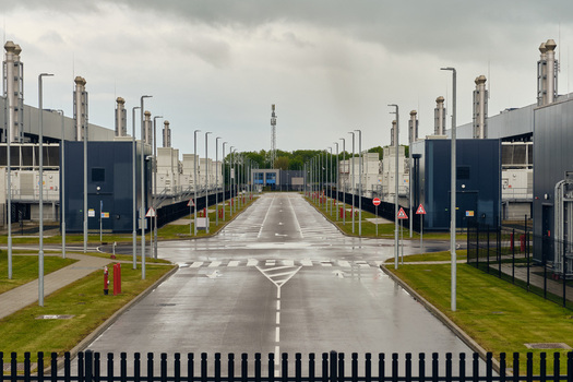Middenmeer Netherlands 17 May 2026 View of Microsoft datacenters on Agriport with modern industrial buildings tall exhaust stacks and streetlights under an overcast sky.
