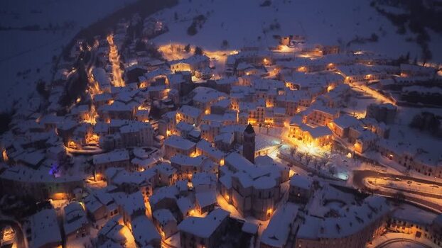 Aerial view of snowy Rivisondoli at night Italy.
