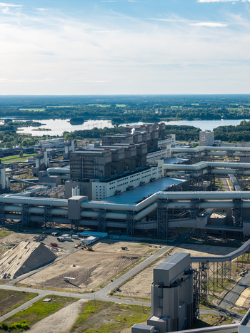 Aerial view of the Janschwalde Power Station featuring large industrial buildings extensive piping infrastructure and cooling towers near a lake in Peitz Brandenburg Germany. Aerial view of the Janschwalde Power Station featuring large industrial buildings extensive piping infrastructure and cooling towers near a lake in Peitz Brandenburg Germany.