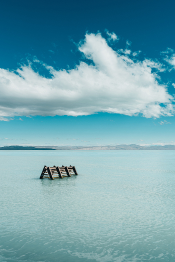 View of a wooden structure partially submerged in the turquoise waters of Lake Argentino under a bright blue sky in El Calafate Santa Cruz Province Argentina.