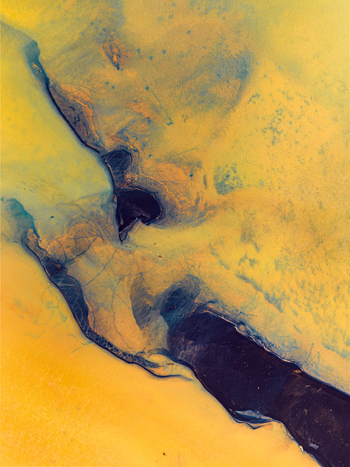 Aerial view of glacial river sediment patterns creating intricate blue and yellow textures across the landscape in Iceland. Aerial view of glacial river sediment patterns creating intricate blue and yellow textures across the landscape in Iceland.