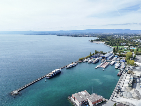 Aerial view of Ouchy Olympique harbor on Lake Geneva with docked passenger ships industrial buildings and clear blue water in Lausanne Vaud Switzerland.