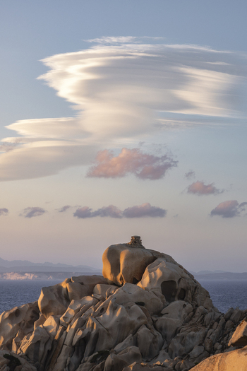 View of the granite rock formations of Capo Testa under dramatic lenticular clouds at sunset Capo Testa Sardegna Italy.
