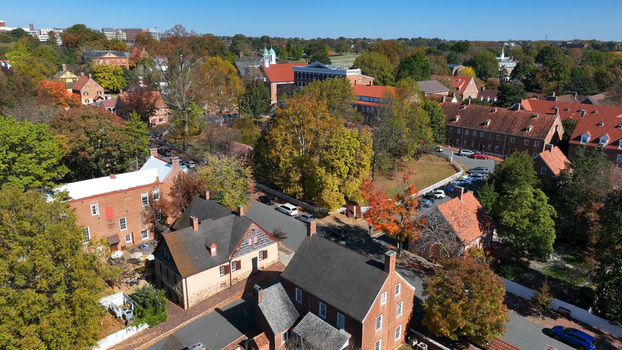 Aerial view of the historic Old Salem district featuring traditional brick buildings vibrant autumn foliage and quiet streets in Winston Salem North Carolina United States.