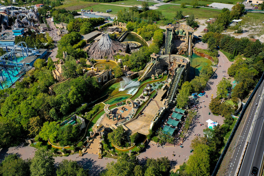 Aerial view of Gardaland Park featuring water rides a volcano attraction and roller coasters surrounded by lush greenery Ronchi Veneto Italy. Aerial view of Gardaland Park featuring water rides a volcano attraction and roller coasters surrounded by lush greenery Ronchi Veneto Italy.