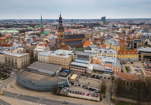 Aerial view of Riga Cathedral and St. Peter s Church surrounded by historic rooftops and urban architecture under a cloudy sky Riga Latvia. Aerial view of Riga Cathedral and St. Peter s Church surrounded by historic rooftops and urban architecture under a cloudy sky Riga Latvia.