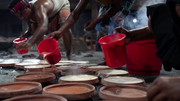 View of workers pouring curd into clay pots in Bogura Bangladesh. View of workers pouring curd into clay pots in Bogura Bangladesh.