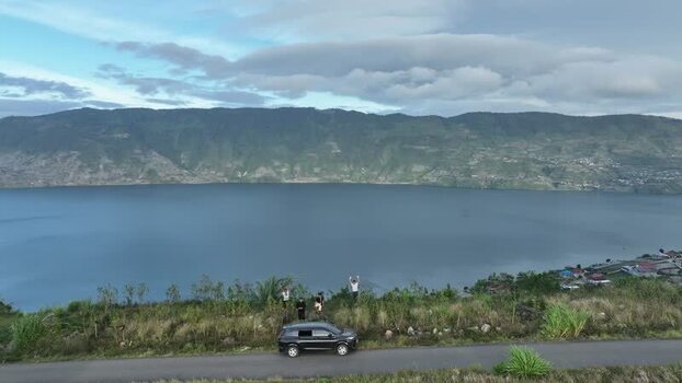 FPV aerial view of Alahan Panjang lake and roadside in Indonesia.