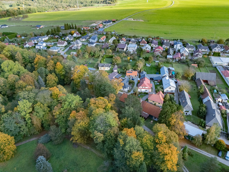 Aerial view of a picturesque village with homes enveloped by a vibrant autumn forest its foliage green and gold Mosovce Zilina Region Slovakia. Aerial view of a picturesque village with homes enveloped by a vibrant autumn forest its foliage green and gold Mosovce Zilina Region Slovakia.