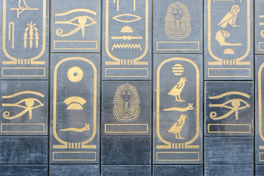 Giza Egypt 16 May 2026 View of the Grand Egyptian Museum facade featuring golden hieroglyphs and cartouches on dark stone panels.